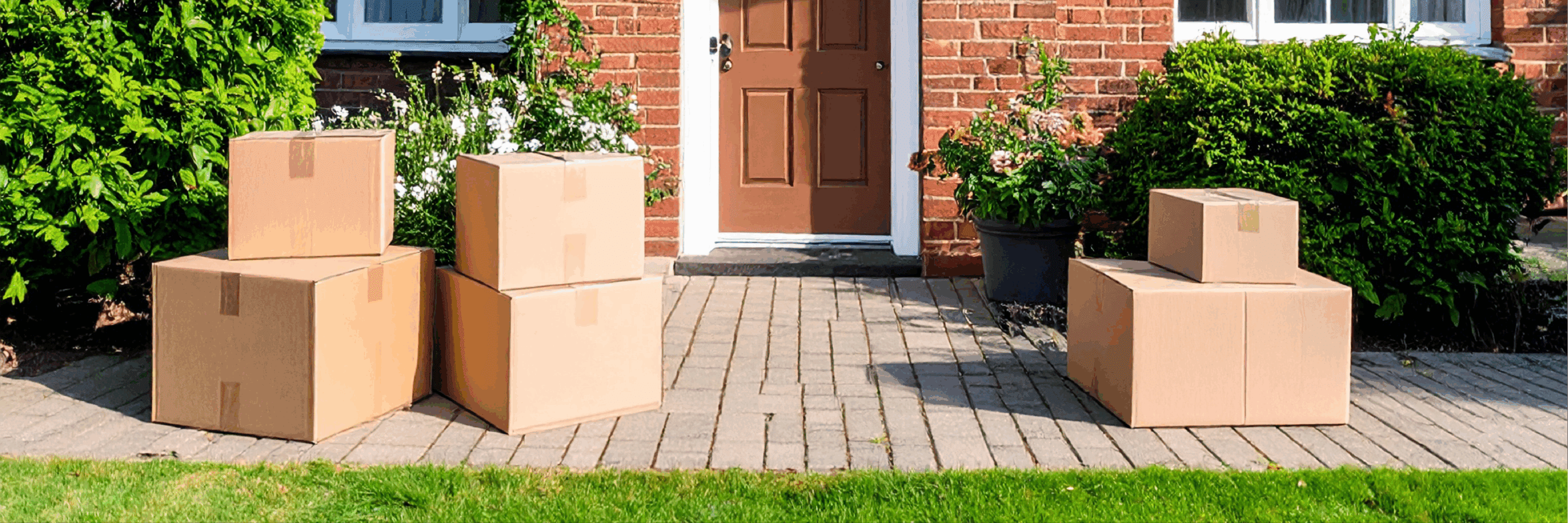 Packed brown cardboard boxes outside a house